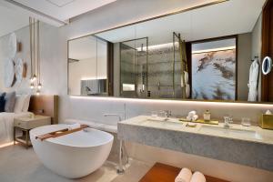 迪拜The St. Regis Downtown Dubai的一间带浴缸和大镜子的浴室