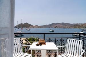 Grikos银滩酒店的阳台上的一张带帽子的桌子和两把椅子
