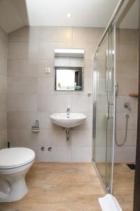 克拉多沃Atrijum Apartments and Rooms的浴室配有卫生间、盥洗盆和淋浴。