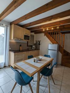 波讷地区圣朱利安Village Océlandes的厨房配有木桌和蓝色椅子