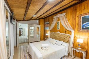 Peñaflor3 bedrooms villa with private pool enclosed garden and wifi at Penaflor的卧室设有白色的床和木墙