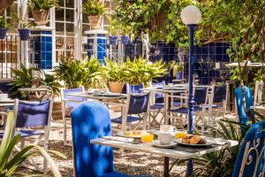 锡切斯雷纳新卡媒介酒店的户外庭院设有桌椅和植物