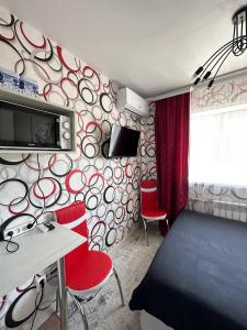 乌斯季卡缅诺戈尔斯克Sport Hotel Terra的一间设有一张床和红色椅子的卧室