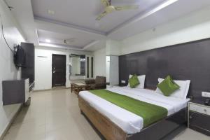 勒克瑙Hotel Dayal的一间卧室配有一张带绿毯的大床
