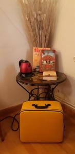 克卢尼Bell'Accueil Chambres d'Hôtes Cluny的一张桌子,桌子上摆着一张桌子,上面放着黄色的手提箱