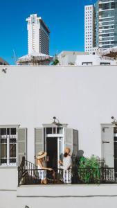 特拉维夫Allegro Neve Tzedek Boutique Suites - By HOMY的两人坐在大楼的阳台上