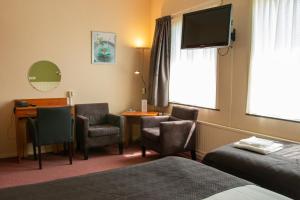 西泰尔斯海灵吾普科斯酒店的酒店客房配有桌椅和电视。
