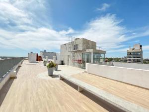 罗萨里奥Estudio en Puerto Norte con PILETA incluida y COCHERA opcional的享有大楼景致的屋顶露台