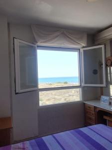 坎佩略Apartamento playa Muchavista的一间卧室设有窗户,享有海滩美景