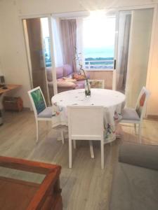 坎佩略Apartamento playa Muchavista的客厅配有白色的桌子和椅子