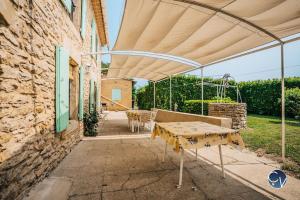 塞兹河畔巴尼奥勒Petit Mas au calme proche centre的一个带桌子和遮阳伞的庭院