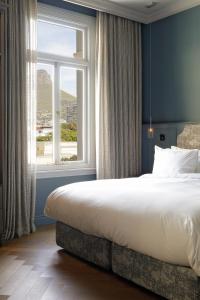 开普敦Labotessa Luxury Boutique Hotel的一间卧室设有一张大床和一个大窗户