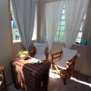 帕拉利亚狄奥尼索PERLA apartments的客房设有桌椅和窗户。