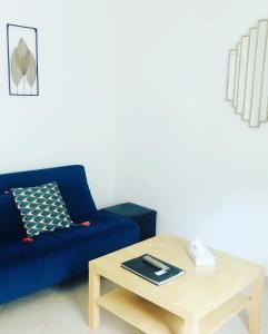 兰斯Appartement 23的客厅配有蓝色的沙发和茶几