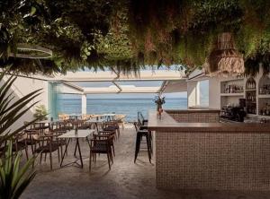 扎金索斯镇Sanpiero Island的一间设有桌椅的海洋餐厅