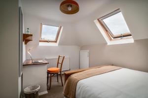 哈罗盖特NO.18的一间卧室配有一张床、一张书桌和两个窗户。