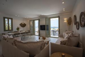 德里奥斯Paros Breeze Luxury Villa的带沙发和桌子的客厅以及用餐室