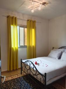 克里比Résidence Hôtelière l'Océane的一间卧室配有一张带黄色窗帘的床和一扇窗户