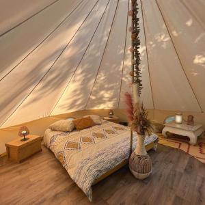 米奥Le Tipi Ethnique au bord de la rivière的帐篷内一间卧室,配有一张床