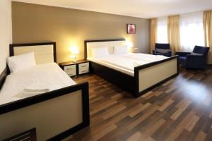 卡普利采科罗娜酒店的酒店客房,配有两张床和椅子