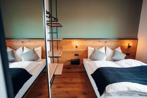 新锡德勒湖畔普巴赫Pur-INN das Gästehaus的一间卧室配有两张床和镜子