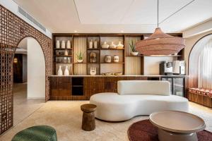 恩波其克Oasis Spa Club Dead Sea Hotel - 18 Plus的客厅配有白色椅子和桌子