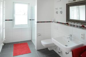 格洛韦Ferienwohnung Sandstrand的白色的浴室设有水槽和卫生间。