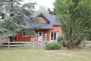 Saint-Jean-de-la-RivièreCharmante maison en bois proche mer的前面有围栏的小木房子
