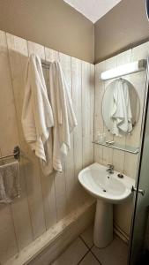 Ligny-en-BarroisHôtel Le Valéran的浴室配有盥洗盆、镜子和毛巾