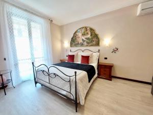 斯佩洛Villamena的卧室配有一张床,墙上挂有绘画作品