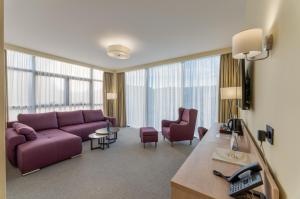 乌日策Hotel Siesta的客厅配有紫色沙发和椅子