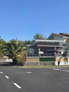 芙蓉Rumah Tamu Sonata的街道前有棕榈树的房子