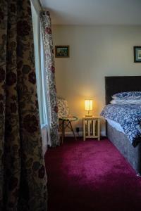 滕比Manorbier House - Lundy North Room的一间卧室配有一张床和紫色地毯