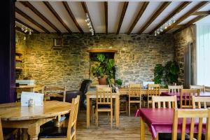 滕比Manorbier House - Lundy North Room的餐厅设有木桌和椅子,拥有砖墙
