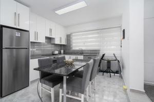 凯里尼亚Villa Blue的厨房配有桌椅和冰箱。