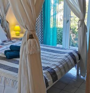 勒唐蓬Cosy & Calme的一间卧室配有带窗帘的床和窗户