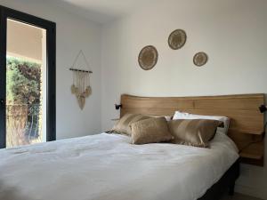 勒拉旺杜La Cigalière à 5 minutes de la plage à pied的卧室配有一张带两个枕头的大白色床