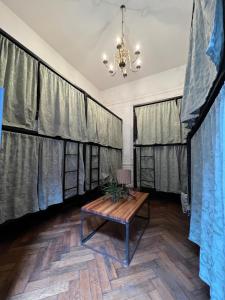 布宜诺斯艾利斯Meridiano Hostel Boutique的配有窗帘、桌子和吊灯的房间