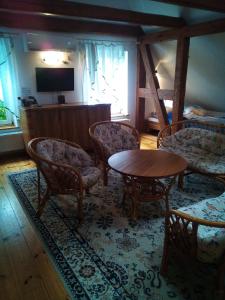 斯瓦热沃斯瓦吉沃马厩农家乐的客厅配有椅子、桌子和电视