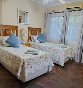 圣卢西亚Stone House的一间卧室设有两张床和两个窗户。