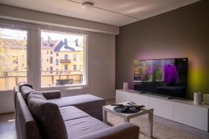 奥斯陆Modern and Central Apartment, 6 mins to Oslo City的带沙发和平面电视的客厅