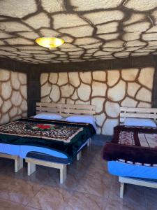 达纳Al-Nawatef ECO camp- Dana Nature Reserve的石墙客房的两张床