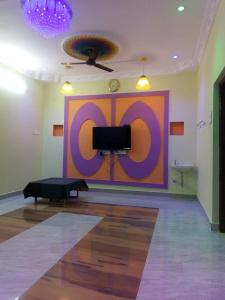 蓬蒂切里ECO VILLA的一间设有大紫色墙壁和电视的客房