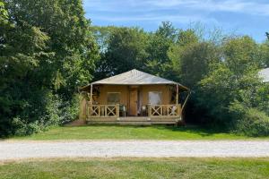 赫劳Glamping Safarilodge 'Grutte Fiif' met airco, extra keuken op veranda en privé achtertuin的凉亭,草上有帐篷