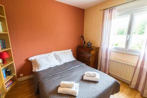 阿姆博斯Clos Fleuri : Amboise Home with Amazing Gardens的一间卧室配有一张床,上面有两条毛巾