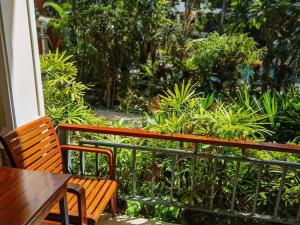 拉威海滩Phuket Meet Holiday Hotel 普吉岛相遇酒店的花园前的两张木长椅和一张桌子