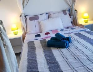 勒唐蓬Cosy & Calme的一间卧室配有一张带蓝色毛巾的床