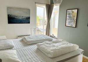TorslandaUnique holiday accommodation on Langholmen in Gothenburgs western archipelago的卧室设有两张单人床和窗户。