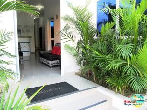曼塔Hostal Playa Imperial Manta的客厅配有黑色沙发和一些植物