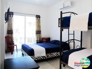 曼塔Hostal Playa Imperial Manta的一间卧室设有两张双层床和一扇窗户。